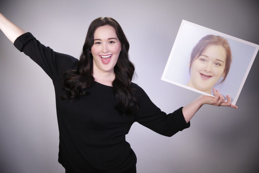 Bethany celebrating and laughing while showing off her photo from before the procedure when she still wore dentures